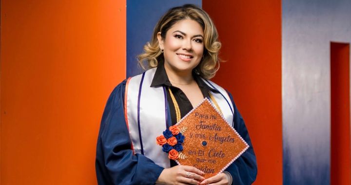 Elsa Trejo wearing graduation regalia and holding her grad cap