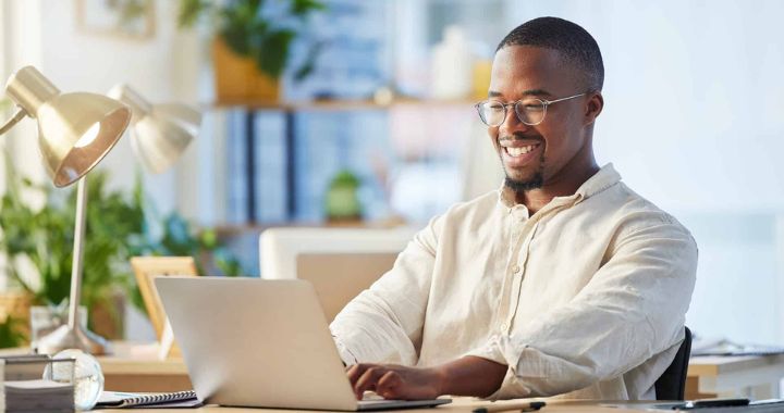 Man smiling while working on a computer