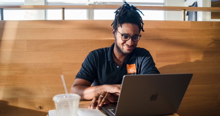 UTSA Online student sitting at a coffee shop with his iPad doing some school work.