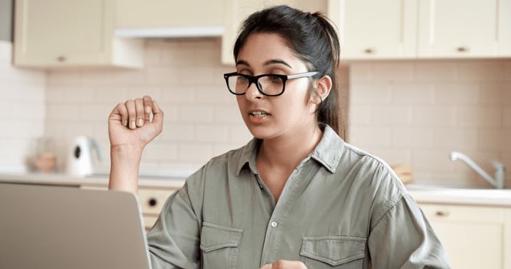 Woman talking in a meeting while on the computer